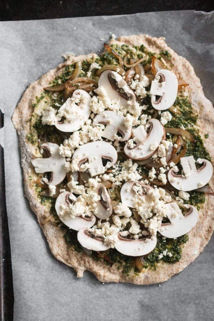 uncooked pizza on a baking sheet