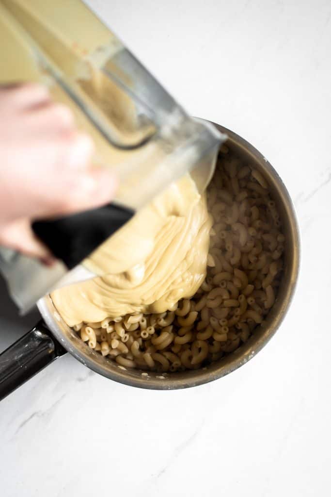 mac and cheese sauce poured on pasta