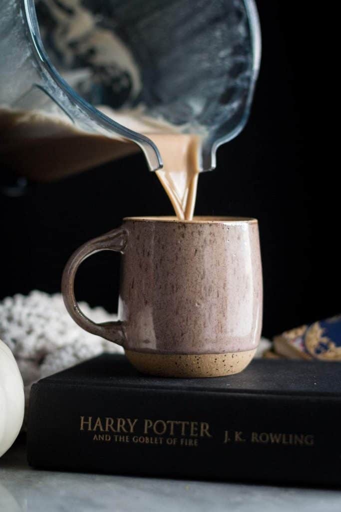 latte being poured in a mug