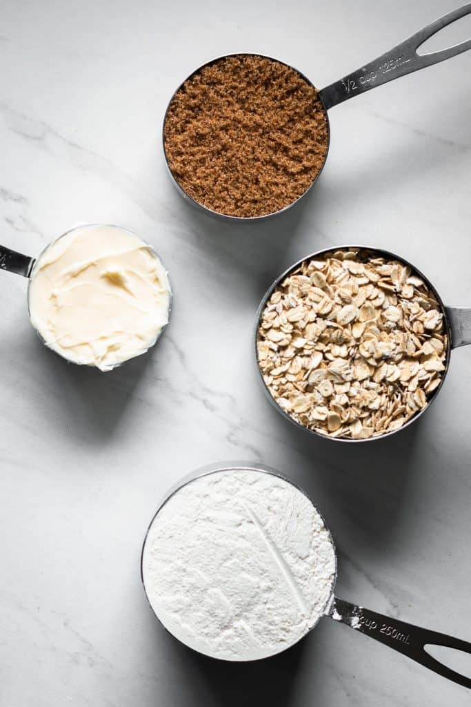 oats, flour, brown sugar and butter in measuring cups
