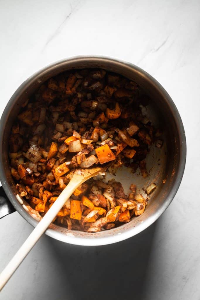 onions, peppers and spices in a saucepan