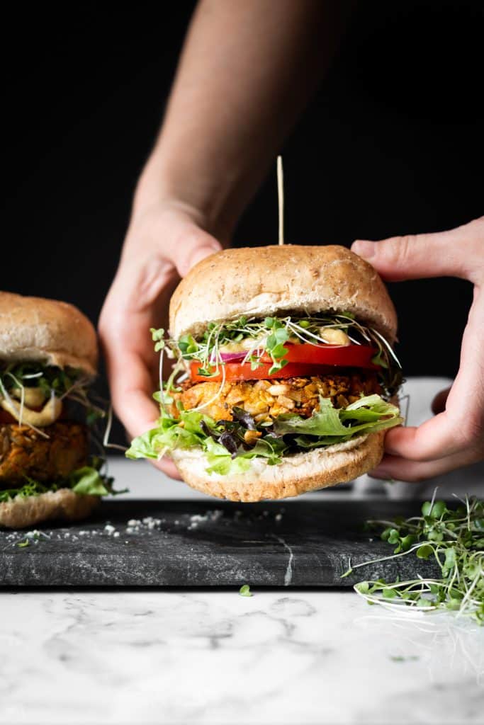 hands holding chickpea burger