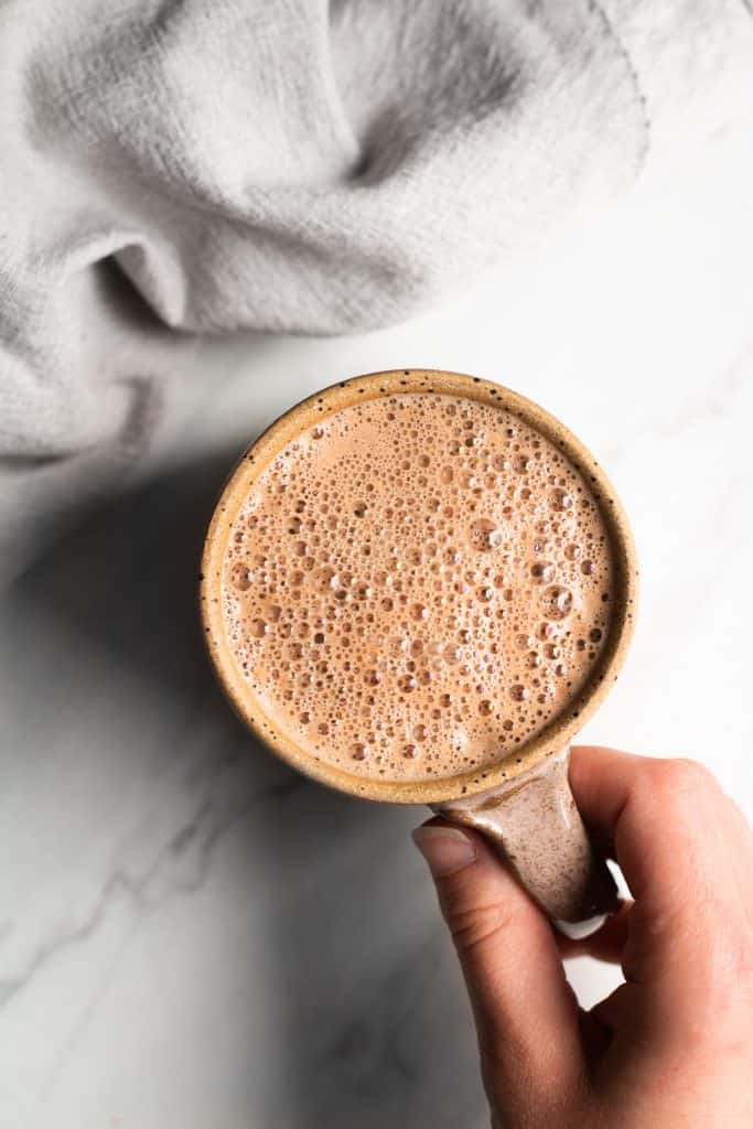hand holding a cup of hot cocoa