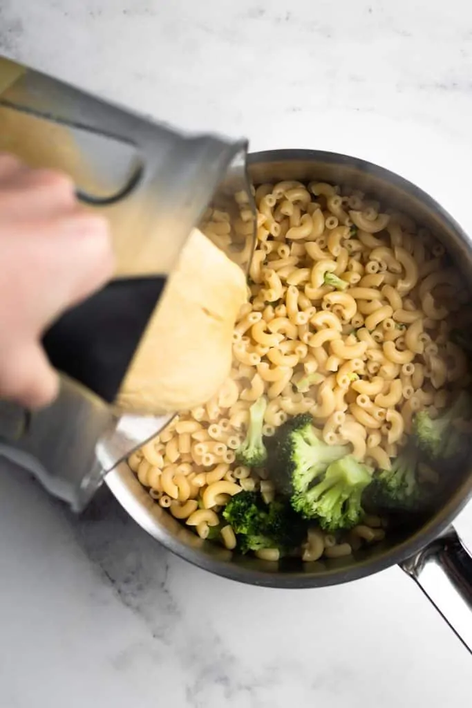 cheese sauce poured over pasta from the top