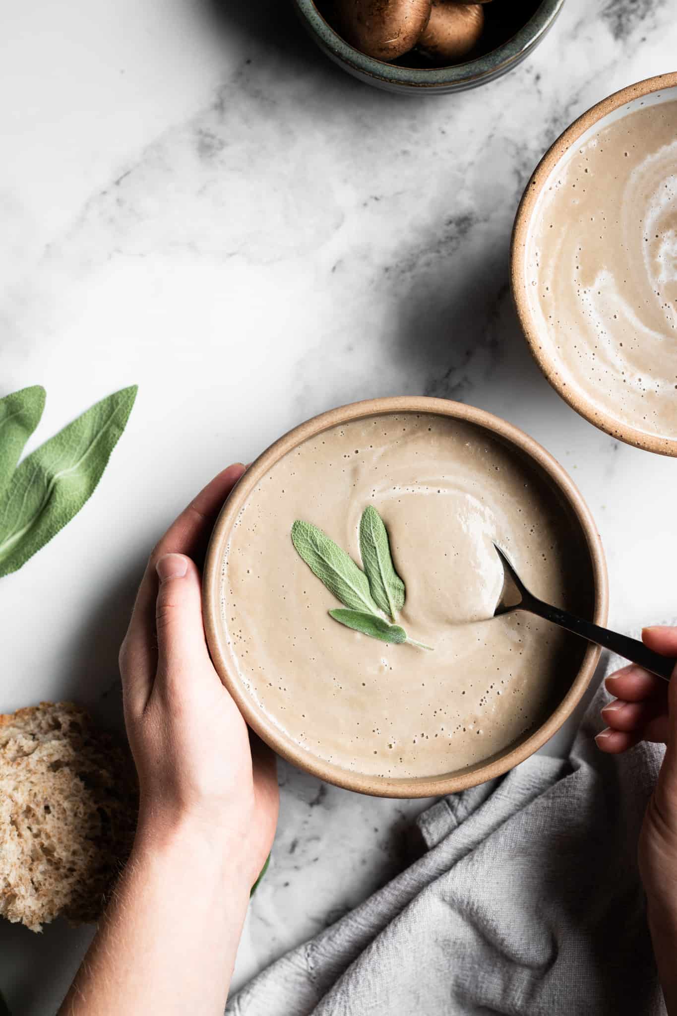 hand holding spoon in cream of mushroom soup