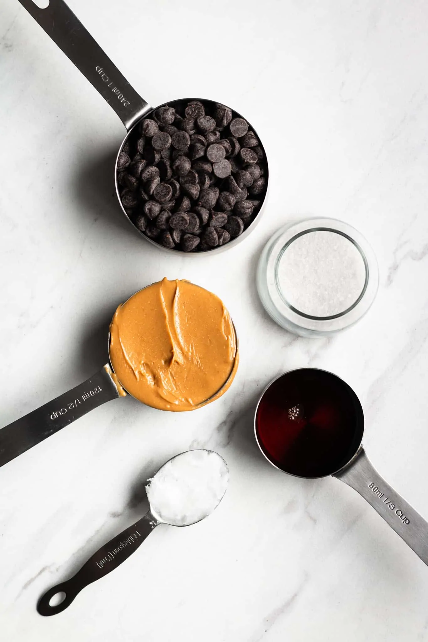 peanut butter, chocolate, salt, maple and coconut oil in measuring cups